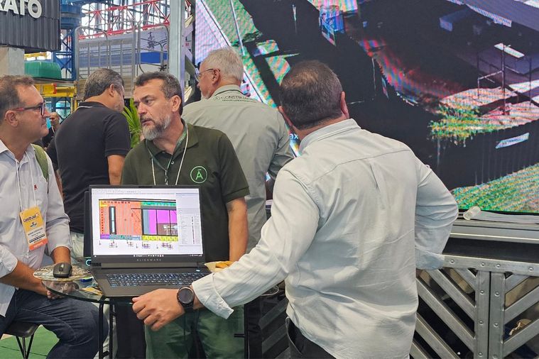 Técnico da ConstruÁgil a mostrar um modelo tridimensional num portátil a um
              visitante, junto a uma estrutura em light steel frame.