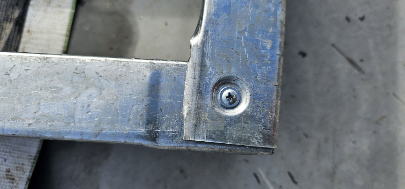 Fotografia de obra da mesma ligação: a ponta desamassada do perfil galvanizado
              encaixada e aparafusada, sem corte nem solda.