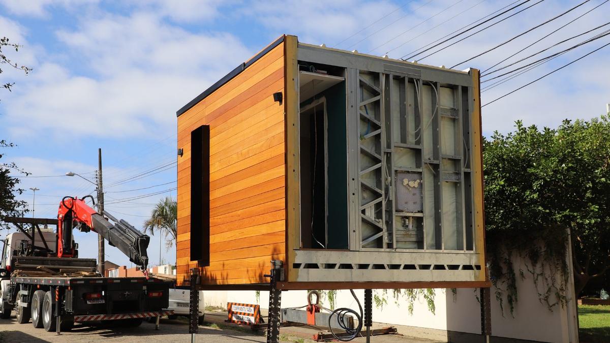 Módulo em light steel frame com revestimento de madeira a ser transportado sobre
              um camião com grua, já montado.