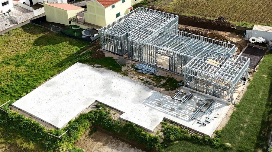 Moradia Patameira vista de cima: implantação em light steel frame sobre a
                  laje, rodeada de campo.